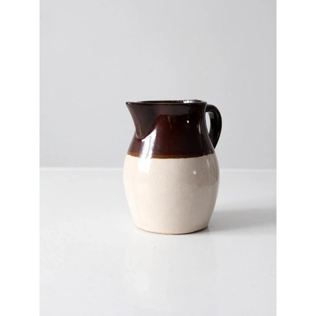 Antique Roseville RRP Co. stoneware pitcher showcasing the timeless beauty and rustic character of early American pottery....