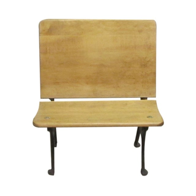 Antique wood and cast iron school row desk with grille style detailing on the legs. There is an indentation on the desk...