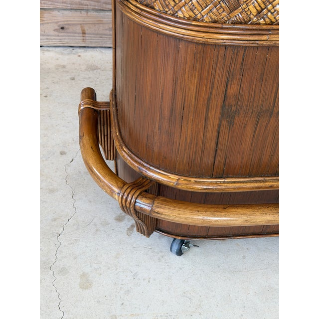 Exceptional vintage coastal bar cabinet crafted in rattan and pencil reed with a beautifully curved front profile and...