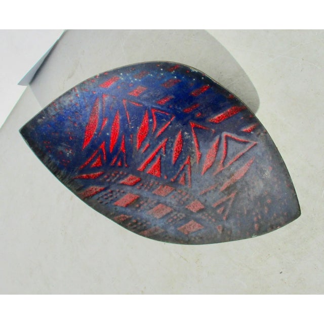Shallow enamel abstracted design tray. Deep navy blue body with an abstracted red design across the center. Slightly...