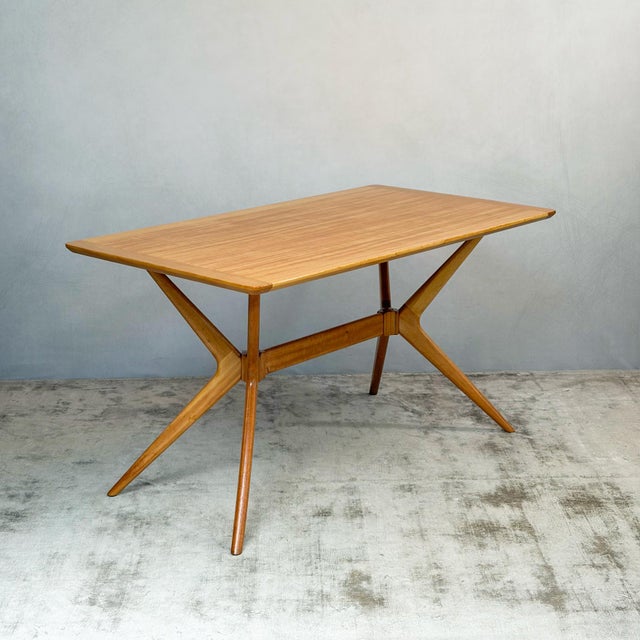 A redford dining table by e. Gomme, known as the 'helicopter' for its unusual base. At each end, four shaped limbs radiate...