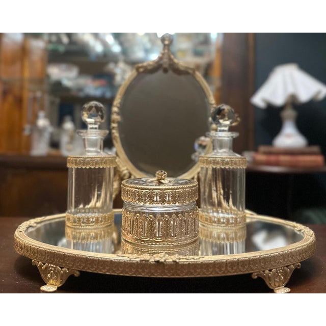 Louis XVI–revival dressing-table set comprising a mirrored plateau on cast feet, an oval tilting mirror with laurel swags...