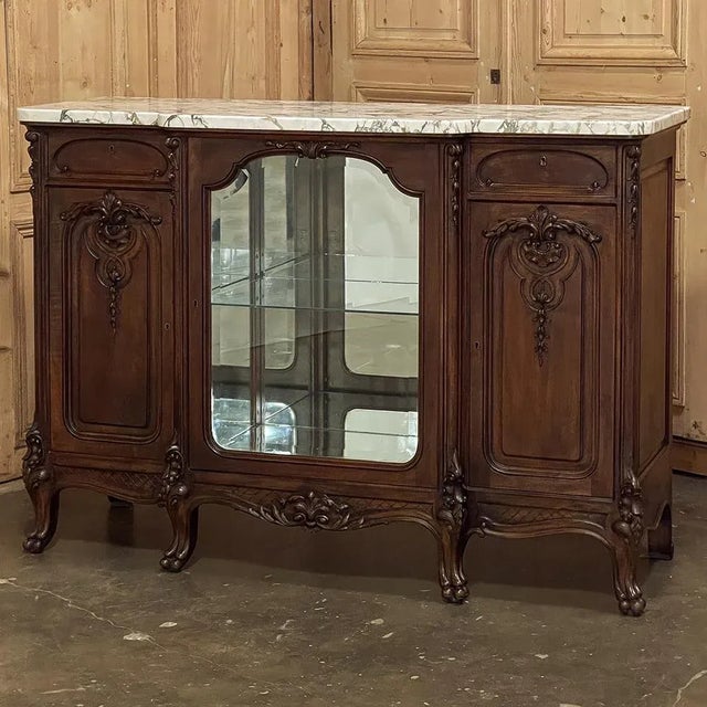 19th Century French Louis XIV Marble Top Walnut Display Buffet for those who wish to possess an exquisitely rendered,...