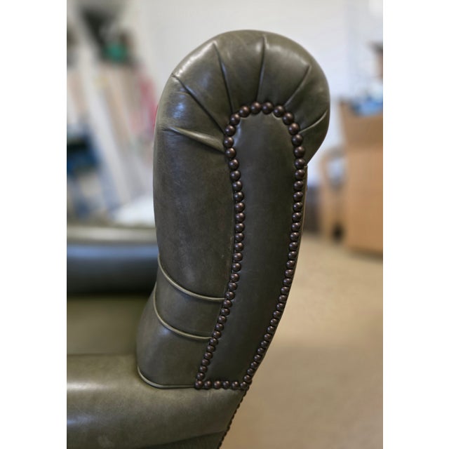 Beautiful like-new custom lounge chair upholstered in a rich olive color leather with antique bronze nailhead detailing...