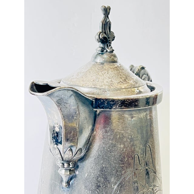 Late 19th century ceramic lined pitcher featuring engraved fuchsias on both sides of the body, a fleur de lis motif finial...