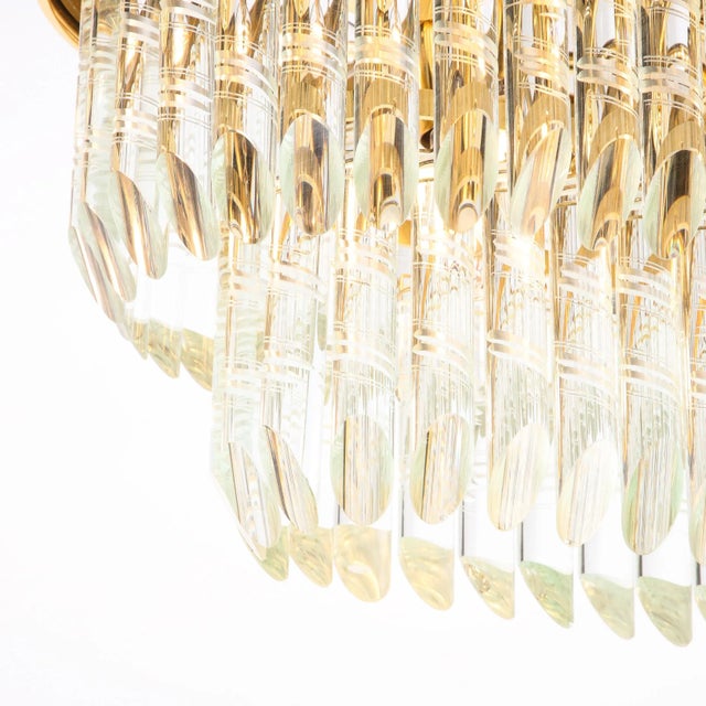 The chandelier originates from Italy circa 1970. Features an oblong geometric frame composed in polished brass, with...