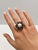 This striking cluster ring by Iris Fine Jewelry is a captivating masterpiece, featuring a harmonious blend of luxurious...