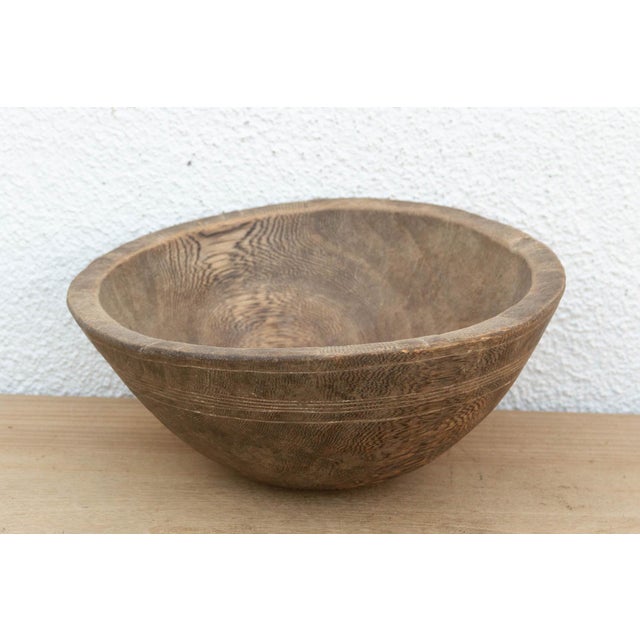 There’s something deeply grounding about holding a vessel carved by hand from a single block of wood. This antique African...