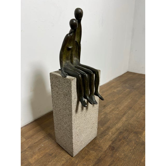 Bronze sculpture of two figures seated upon a cast stone pedestal, ca. 1980s, by the internationally renowned mid century...