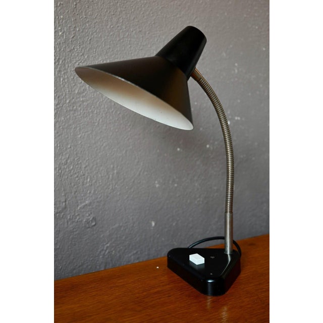 This lamp, with its understated charm reminiscent of mid-century German design, has gracefully weathered the decades...