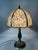 The lampshade is made of yellow-green colored stone mosaic, paired with a black-gold two-tone metal lamp body (with carved...