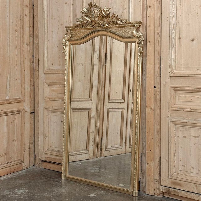 An elegant 19th century French Louis XVI transitional mirror, constructed with a wood frame finished in hand-applied gesso...