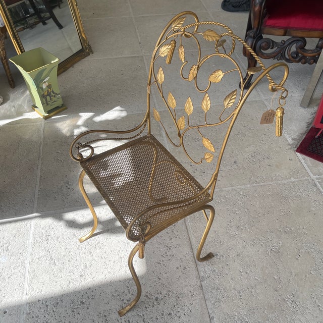 This is a vintage Italian Hollywood Regency gold gilt iron side chair with a leaf and tassel design.