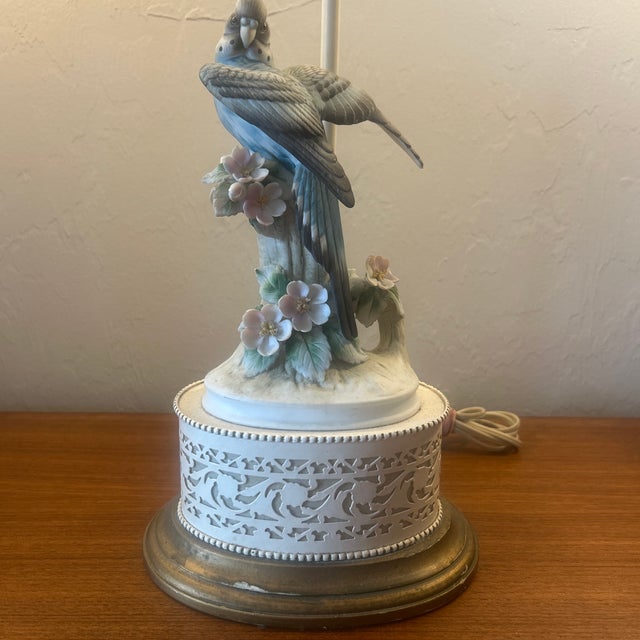 The lamp features a detailed bisque porcelain finish the bird is perched upon a tree stump with wings spread