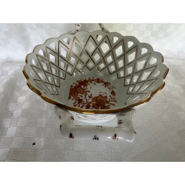 A Chinese Bouquet Pattern, porcelain open weave basket with 2 handles.in rust. The piece is hand painted with red floral...