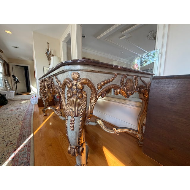 Exceptional antique French Rococo Revival table featuring a richly veined marble top resting on an elaborately carved...