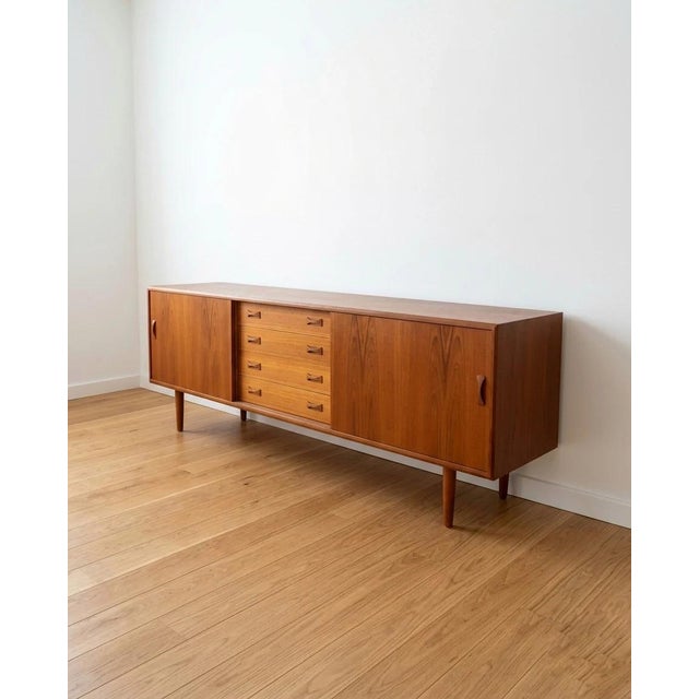 Danish teak sideboard from the 1960s, 209 cm. The frame features two sliding doors—one on each side—with vertical handles,...
