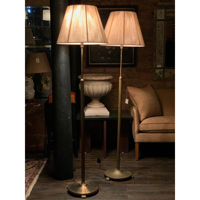 These two Danish Art Deco brass floor lamps are a near-pair with identical designs and slight variations in metal tone....