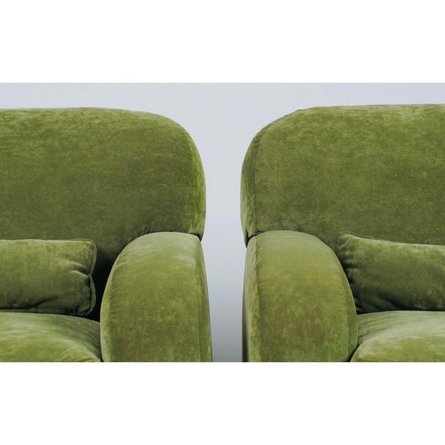 A handsome pair of oversized lounge chairs upholstered in luxurious olive green suede, combining the relaxed comfort of...