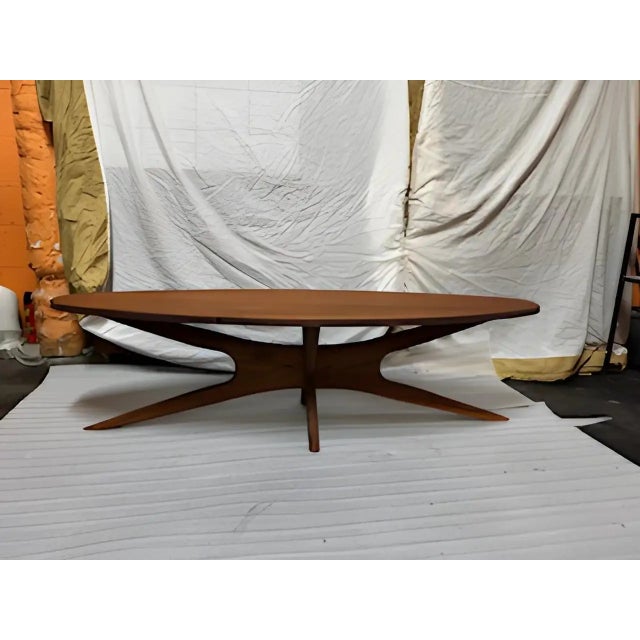 Mid century modern coffee table with sculpted base. This has all of the characteristics of an Adrian Pearsall down to the...