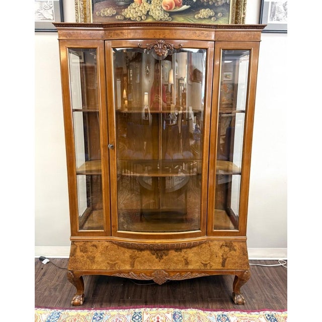 This vintage bowfront curio china cabinet features richly figured burled walnut veneers, a gracefully curved glass door,...