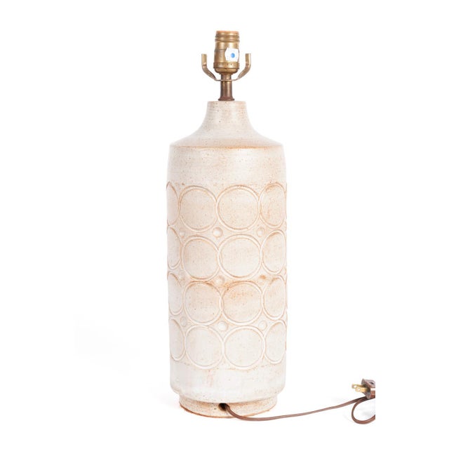 White and pink-toned Mid Century Modern pottery table lamp. The lamp features glazed earthenware table with circular...