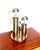 An elegant space age table lamp with a sculptural design, composed of three chromed metal tubular elements arranged in a...
