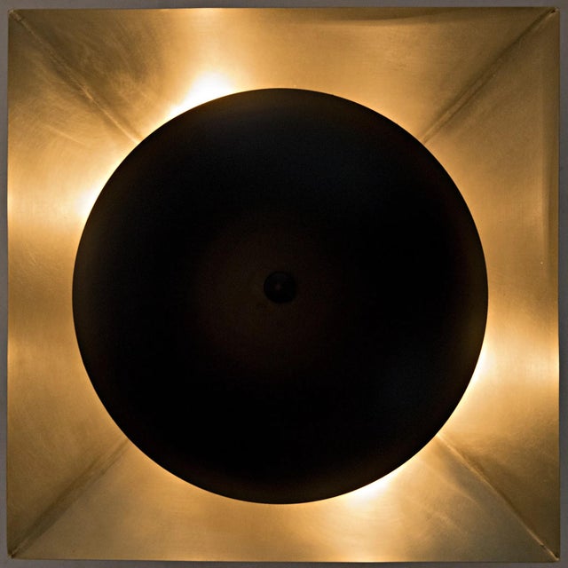 A circle of black metal diffuses the light from this sconceÕs bulb. When lit, the bulb reflects beautifully off of the...
