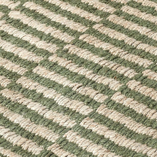 Hand woven jute rug in natural and olive tones. Alternating color pattern creates a rhythmic tile-like effect. Please note...