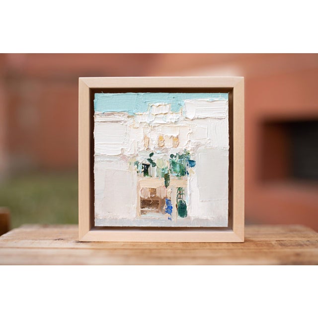 This artwork depicts a serene urban scene, characterized by soft, muted colors and an impressionistic approach to form....