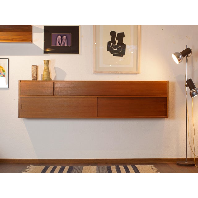 A beautiful and unique wall shelf from the early 1960s. The piece offers ample storage space for books, dishes, glasses,...