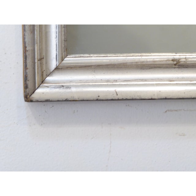 This 19th Century silverleafed mirror has an old patina. it measures 26.5"H x 20.75"W and is set up to hang vertically,...