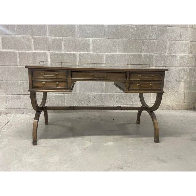 This elegant writing desk, crafted in Holland, Michigan in 1969, features its original finish and brown leather top with...