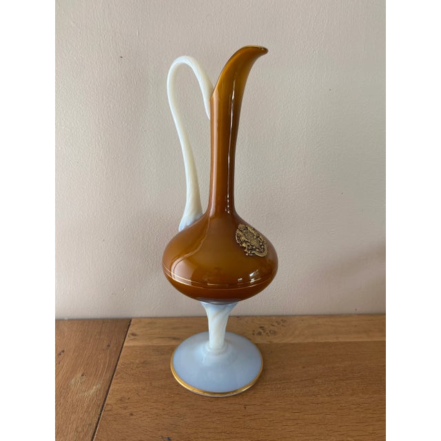 Hot-blown glass pitcher. Amber glass for the body and neck. White opaline glass for the handle and pedestal. Gold trim...