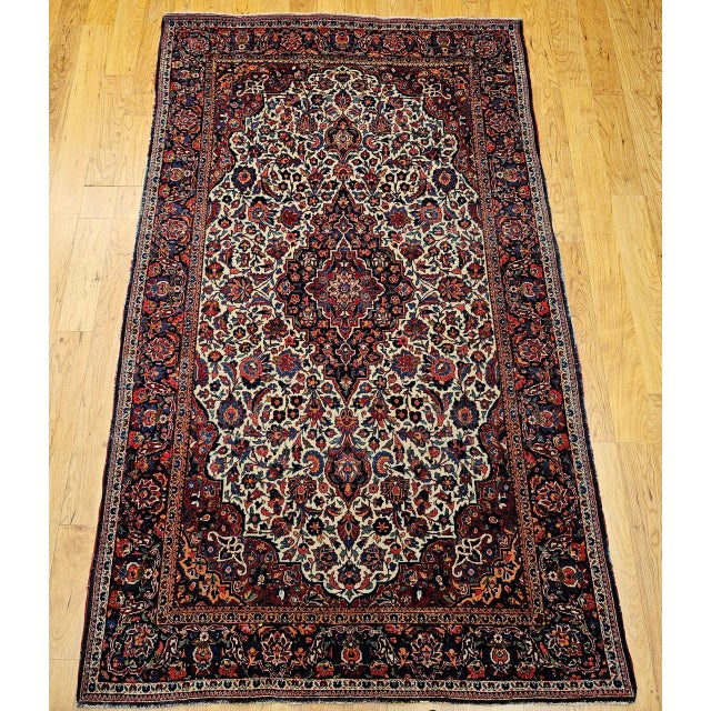 "An early 20th century hand-knotted Persian Kashan rug, distinguished by its rare and coveted ivory field color and...