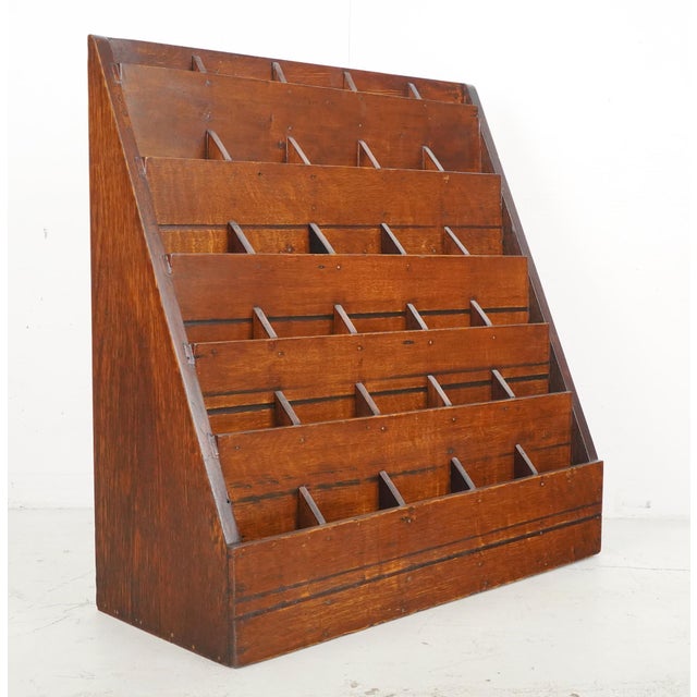 Antique retail display rack made of oak with thirty slots in six rows. Similar tiered wooden racks were commonly used in...