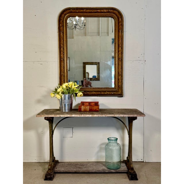 This antique French gilt mirror features a lovely aged patina, with intricate gilt detailing. The original glass is still...