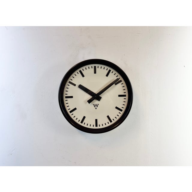 This wall clock was produced by Pragotron in former Czechoslovakia during the 1960s. It features a brown bakelite frame...