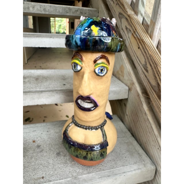 Abstract two-sided studio pottery vase in the shape of a man's face on one side and a woman's face on the other.