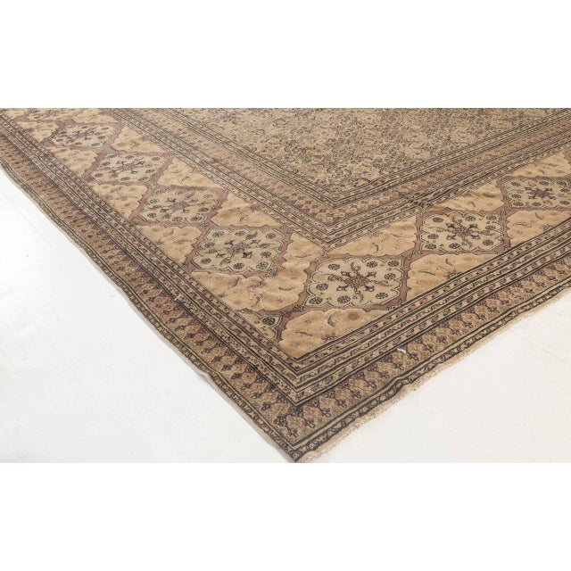 A late 19th century antique Persian Meshad rug, the pale camel field with a dense herati pattern within a broad dusty rose...