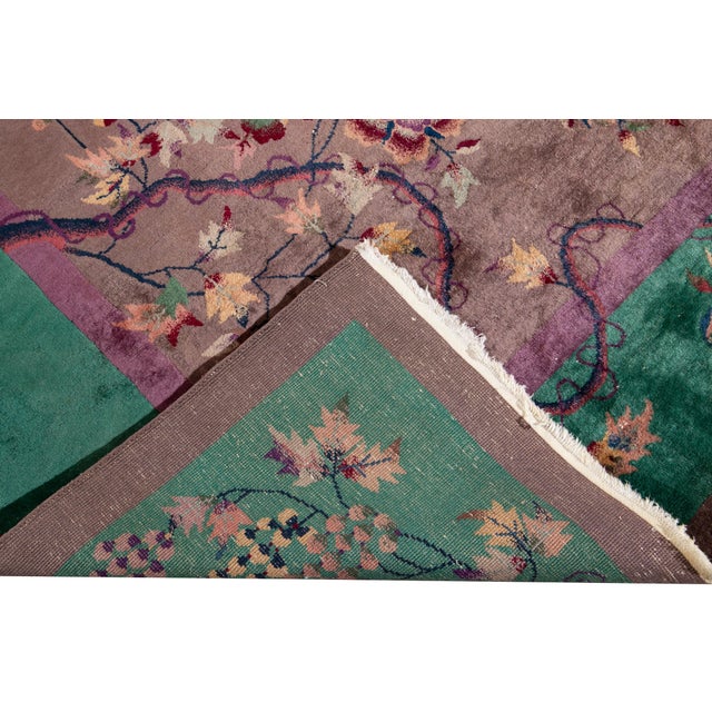 This stunning antique Chinese Art Deco rug (circa 1920s-1930s) features a rich plum-brown field and a vibrant emerald...