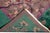 This stunning antique Chinese Art Deco rug (circa 1920s-1930s) features a rich plum-brown field and a vibrant emerald...