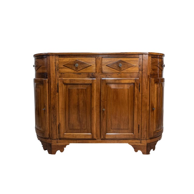 An Italian walnut credenza from the 19th century with four drawers over four doors, diamond motifs and rounded sides. This...