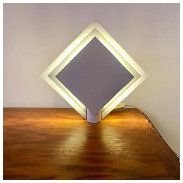 A veritable light sculpture! This white metal geometric wall light has 3 layers as a diamond. The layers give the lamp a...