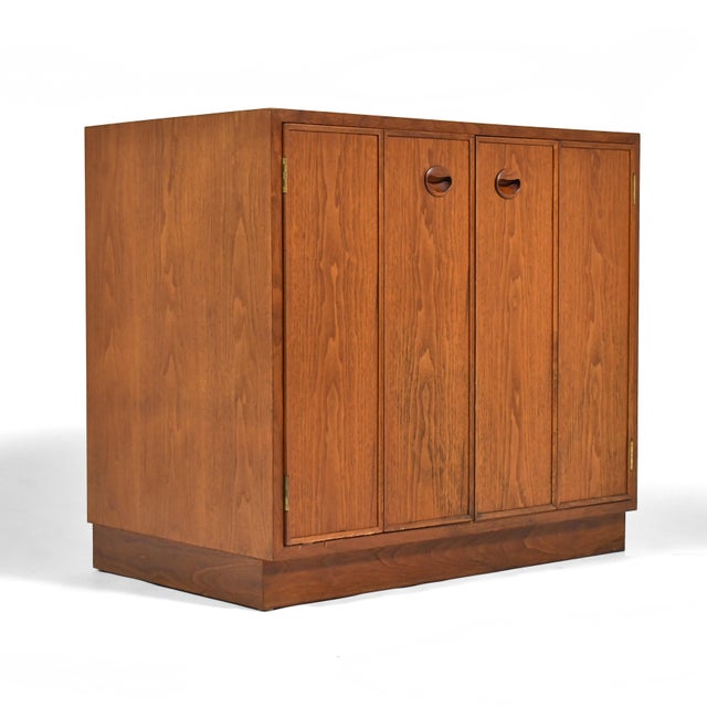 Simple, clean-lined and versatile, this Ed Wormley cabinet by Dunbar features two bi-fold doors concealing one compartment...