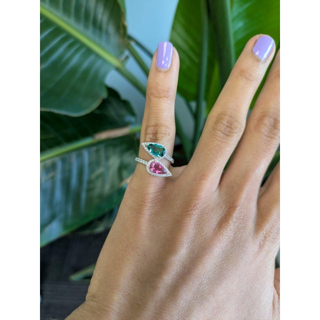 A pink tourmaline and a blue indicolite tourmaline sit side by side in a romantic toi et moi design at the centre of this...