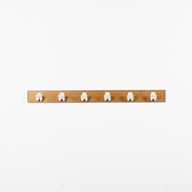 Large wall-mounted coat rack made of pine, equipped with six white lacquered aluminum hooks. This model was designed by...