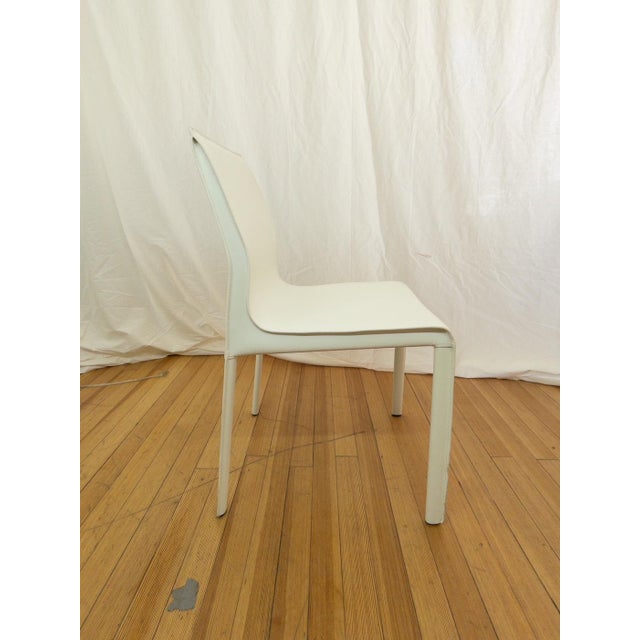 Nuevo Colter dining chair in white leather featuring a sleek chrome steel frame and a clean, contemporary silhouette. The...