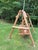 Substantial rustic outdoor swing featuring a freestanding solid log frame and a generously sized double seat with...
