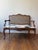 An elegant 1870 Louis XV settee featuring a caned wicker back, a carved European frame, and newly upholstered neutral...